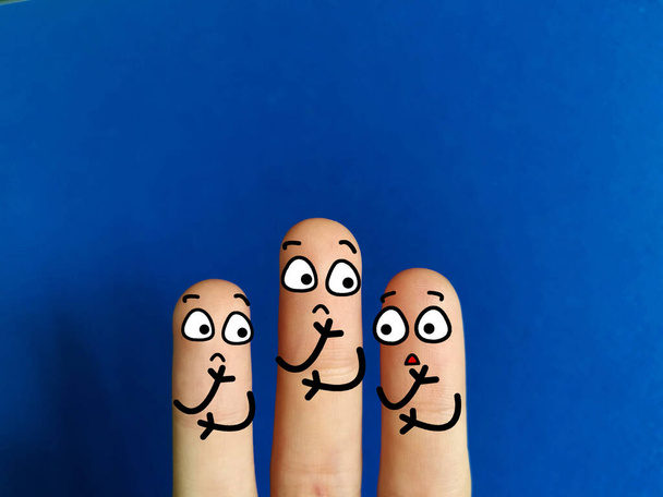 Three fingers are decorated as three person. They are sad and worried. - Foto, afbeelding