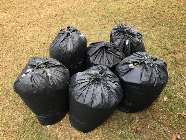 Des sacs poubelles noirs dans la cour. Concentration sélective. - Photo, image
