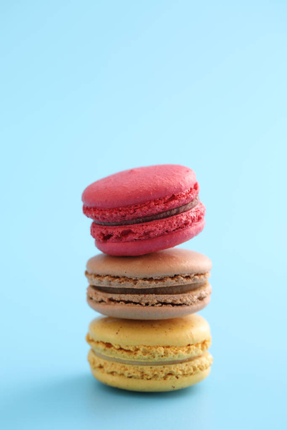 Colorful macarons isolated in blue background - Φωτογραφία, εικόνα