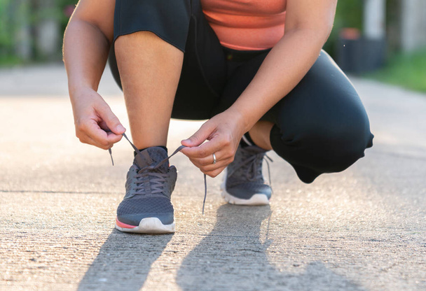 mujer preparándose para correr atando cordones zapatillas en casa para correr estilo de vida activo.  - Foto, Imagen