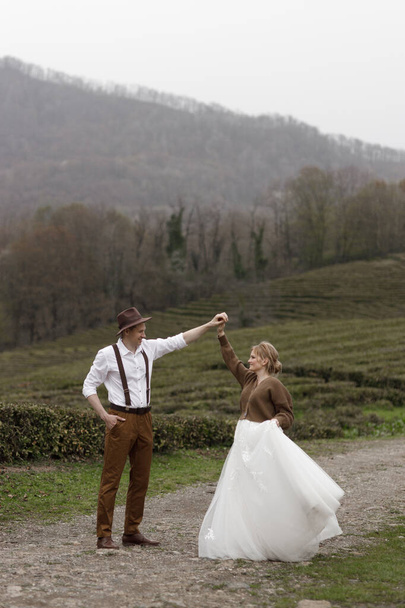 A farm-style wedding on a mountain tea plantation. The couple enjoys the view of nature among the tea plantations. - Foto, afbeelding