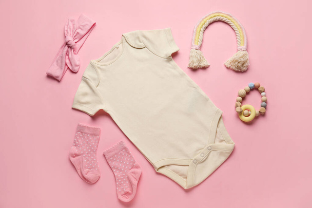 Set of baby clothes, socks and toy on color background - Photo, Image
