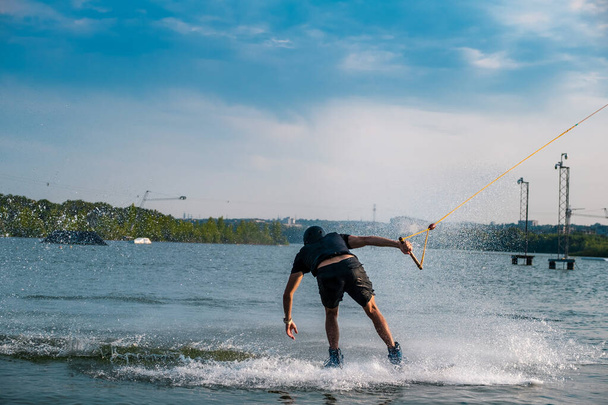 Widok człowieka balansującego na wakeboardzie na rzece - Zdjęcie, obraz