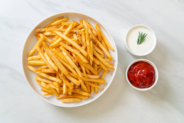 French fries or potato chips with sour cream and ketchup - Fotoğraf, Görsel