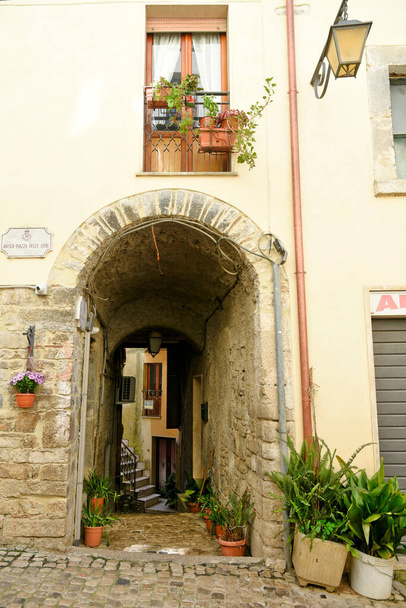 Sonnino, Włochy, 05 / 10 / 2021. Ulica pomiędzy starymi średniowiecznymi kamienistymi budynkami historycznego miasta w regionie Lacjum, Włochy. - Zdjęcie, obraz