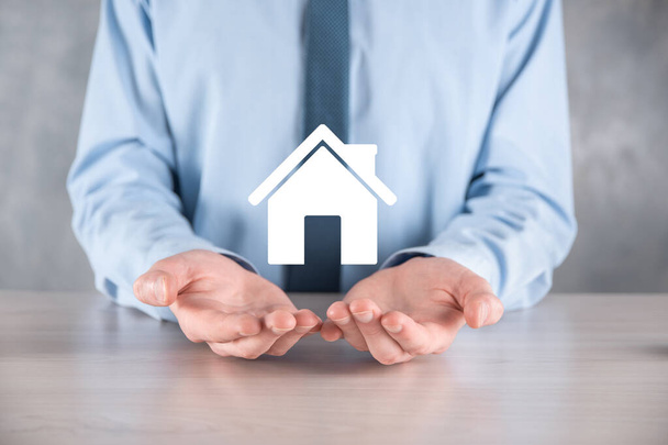 Real estate concept, businessman holding a house icon.House on Hand.Property insurance and security concept. Protecting gesture of man and symbol of house - 写真・画像