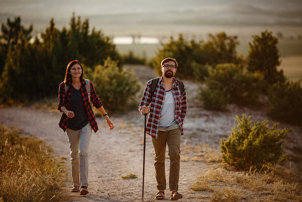 Πορτρέτο του ευτυχισμένου νεαρού ζευγαριού που διασκεδάζει στο ταξίδι πεζοπορίας. Ευτυχισμένο πολυφυλετικό ζευγάρι, νεαρή Ασιάτισσα και Καυκάσιος. Νέοι που περπατούν στη φύση. - Φωτογραφία, εικόνα