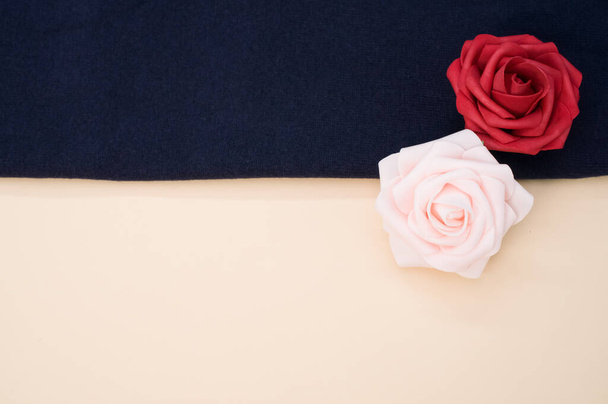 A top view of roses from satin ribbon on a blue cloth - Photo, Image