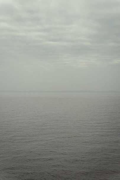 A scenic view of a sea on a cloudy sky background - Fotó, kép
