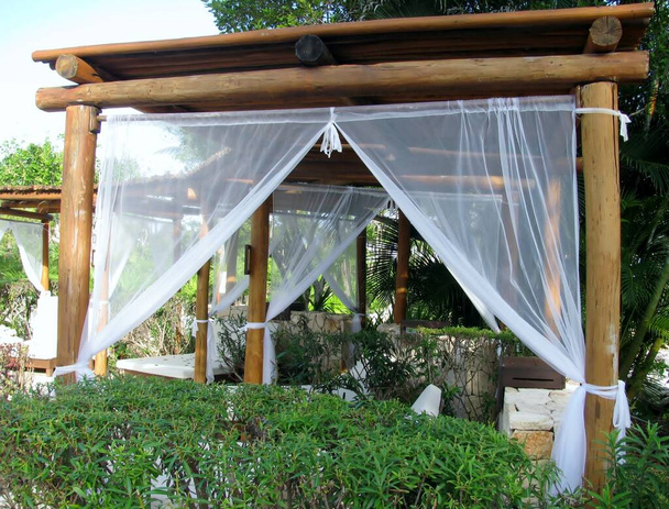 Cozy wooden log cabanas with white tulle curtains. Cancun, Mexico. - Fotografie, Obrázek