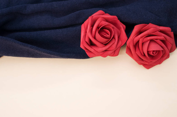 A top view of roses from satin ribbon on a blue cloth - Zdjęcie, obraz