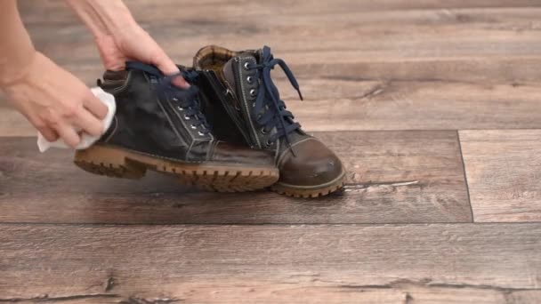Las manos femeninas limpian los zapatos marrones con un trapo mojado blanco del primer plano de la suciedad - Metraje, vídeo