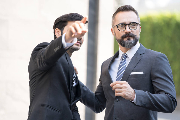 Liikemies esittelee aurinkokennotyötä liikemiehelle. Nuori liikemies osoittaa sormella. - Valokuva, kuva