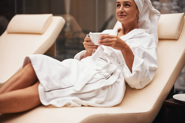 Charming adorable brunette business woman with towel on her head enjoy luxury service in health beauty center - Fotó, kép