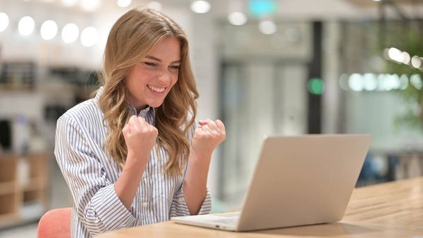Aufgeregte Geschäftsfrau feiert Erfolg auf Laptop im Büro - Foto, Bild