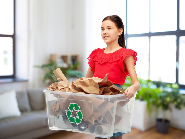 smiling girl sorting paper waste at home - 写真・画像