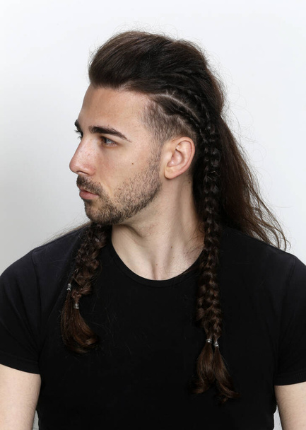 Stylish male model with braids posing in studio on isolated background. Style, hairstyle, fashion concept. - Фото, зображення