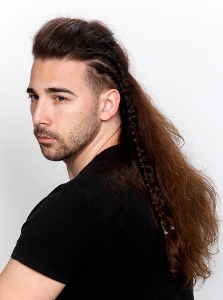 Stylish male model with braids posing in studio on isolated background. Style, hairstyle, fashion concept. - Foto, Imagen