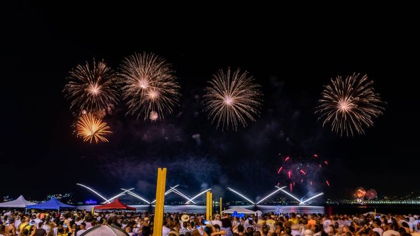 NITEROI, RIO DE JANEIRO, BRAZIL - JANUÁR 2020: Éjszakai képek szilveszteri (Reveillon) tűzijátékkal az égen. Az emberek figyelik a pirotechnikai ünnepség fényeit és színeit. - Fotó, kép