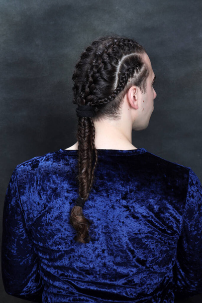 Attractive male model with braids posing in studio. Avantgarde, style, fashion concept. - Photo, Image