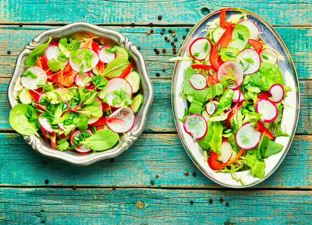 Vegaaninen salaatti retiisistä, pippurista, kaalista ja vihreästä salaatista.Vihreä salaatti puupohjalla - Valokuva, kuva