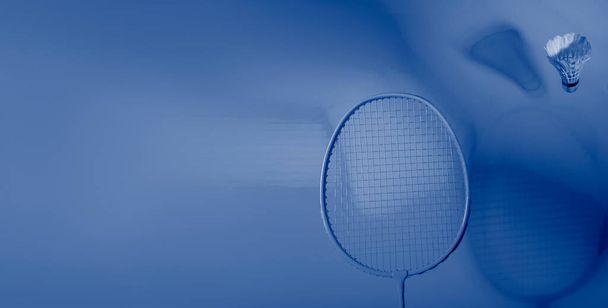 raqueta de bádminton y lanzadera sobre fondo azul. Concepto deportivo profesional - Foto, imagen