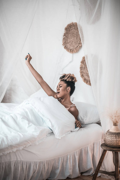 Sleepy young woman stretching in bed - Photo, Image