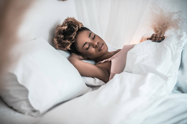 African american woman sleeping soundly in bed - Fotografie, Obrázek