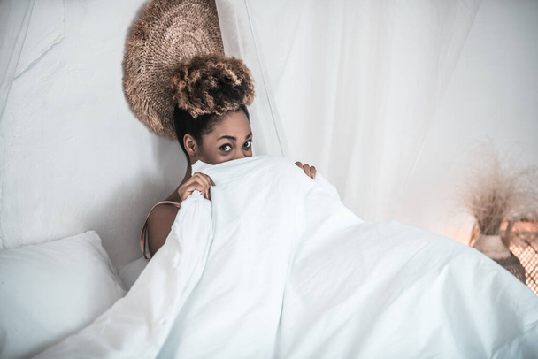 Awakened woman sitting in bed covering blanket - Fotografie, Obrázek