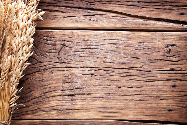 Ears of wheat on old wooden table. - Valokuva, kuva