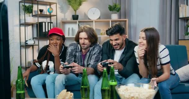 Fun-Konzept, wo attraktiv lächelnd glücklich sorgenfrei vielfältige Gruppe von Freunden Spaß zusammen beim Spielen von Videospielen auf dem Fernseher zu Hause - Filmmaterial, Video
