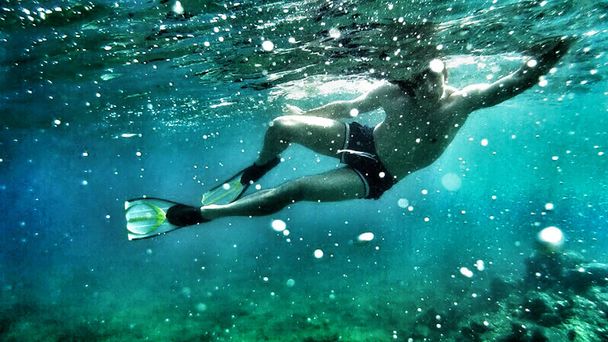 Plongée sous-marine. Détente, sport, soleil, voyage, mode de vie sain. Il plonge sous l'eau. Concept vacances d'été. - Photo, image