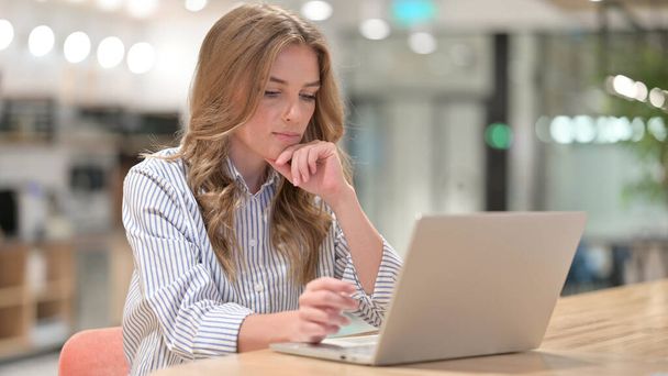 Femme d'affaires Penser et travailler sur ordinateur portable dans le bureau - Photo, image