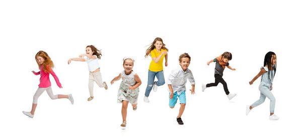 Group of elementary school kids or pupils running in colorful casual clothes on white studio background. Creative collage. - Valokuva, kuva