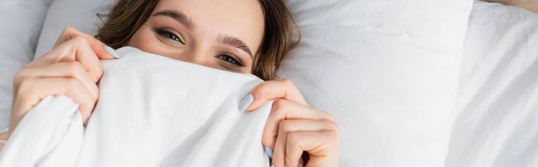 Top view of woman covering face with blanket and looking at camera, banner  - Foto, Imagem