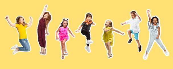 Group of elementary school kids or pupils jumping in colorful casual clothes on yellow background. Collage. - Valokuva, kuva