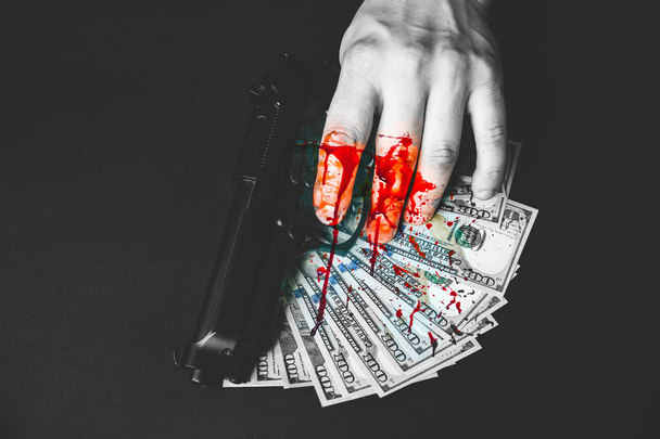 Eli kanlı bir adam silah tutuyor. Masada kötü kazanılmış para. Dolar çalındı. Katil suç kavramı. - Fotoğraf, Görsel
