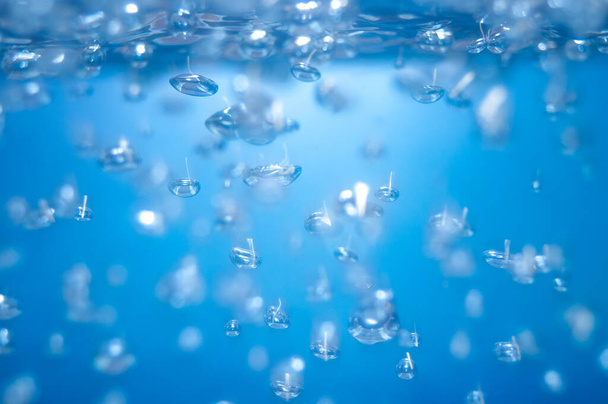 air bubbles in the water isolated on blue background . - Photo, Image