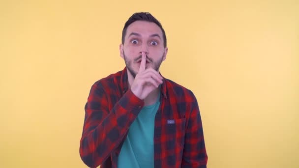 De man gebaart stilte, stilte gebaar met een vinger op zijn lippen - Video