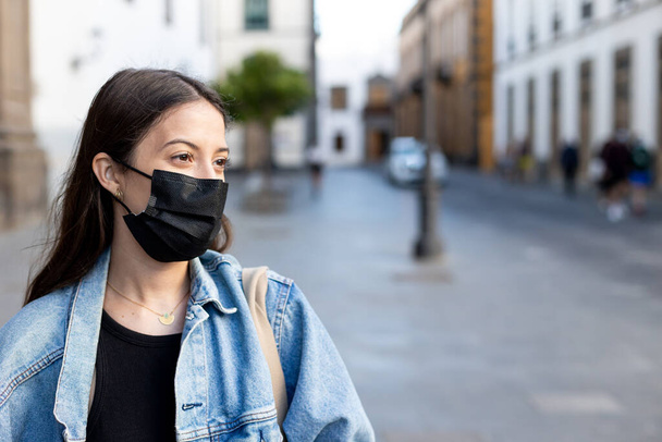 Chica joven con máscara quirúrgica en la calle - Foto, imagen