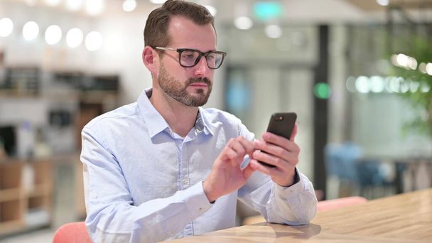 Businessman using Smartphone in Office - Photo, Image