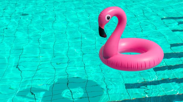 Pozadí letního konceptu. Růžové nafukovací plameňák v bazénu vody pro letní pláž pozadí. Plovoucí párty u bazénu - Fotografie, Obrázek