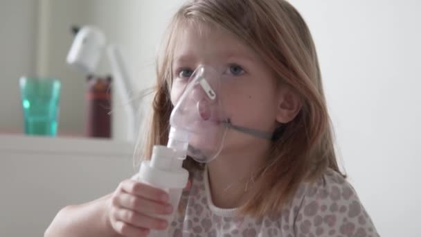 Ένα άρρωστο κοριτσάκι εισπνέει στο σπίτι μέσω ενός νεφελοποιητή. - Πλάνα, βίντεο