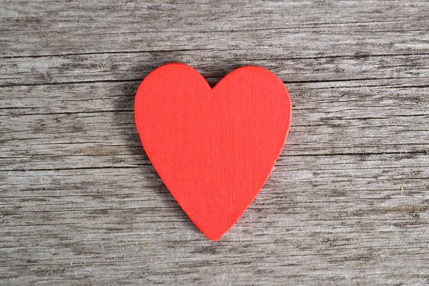 A red wooden heart lies on a wooden background.Background for greeting cards for Valentine's Day, Birthday, Mother's Day.Top view.Flat styling style.Copyspace - Foto, imagen