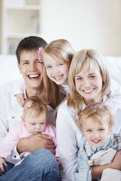 Une famille heureuse avec des enfants sur le canapé à la maison - Photo, image