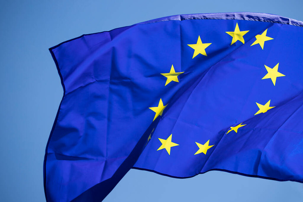 Waving European Union flag on blue sky. - Фото, изображение