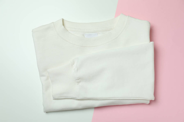 Folded white sweatshirt on two tone background - Zdjęcie, obraz