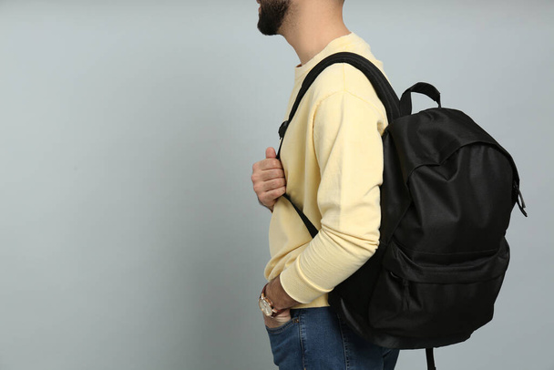 Young man with stylish backpack on light grey background, closeup. Space for text - Fotoğraf, Görsel
