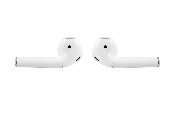 White wireless earbuds headphones lying in front of each other. White earflaps isolated on white background - Photo, Image