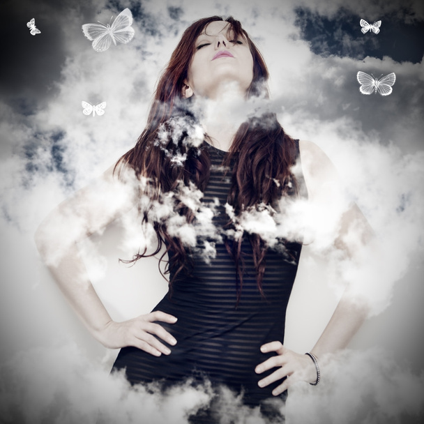 güzel bir genç kadın bir arka planda bulutlar - Fotoğraf, Görsel